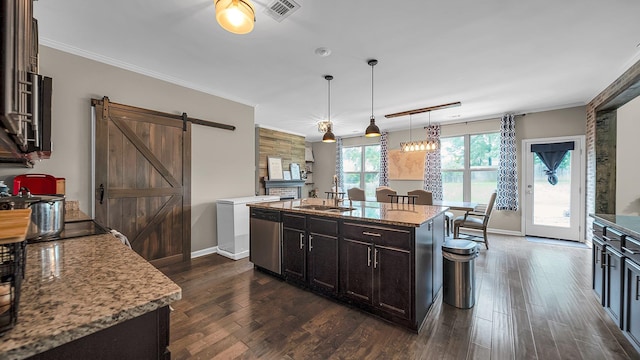 kitchen featuring dishwasher, a center island, a barn door, dark hardwood / wood-style flooring, and pendant lighting