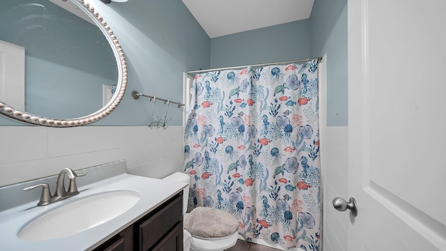 bathroom with vanity, curtained shower, toilet, and tile walls