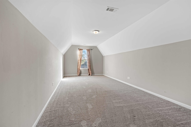 additional living space featuring carpet flooring and vaulted ceiling