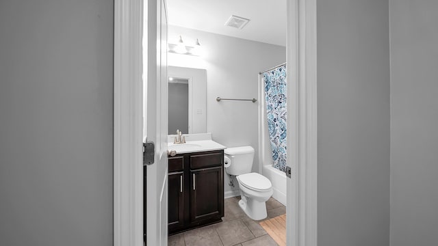 full bathroom with tile patterned flooring, shower / bath combo, vanity, and toilet