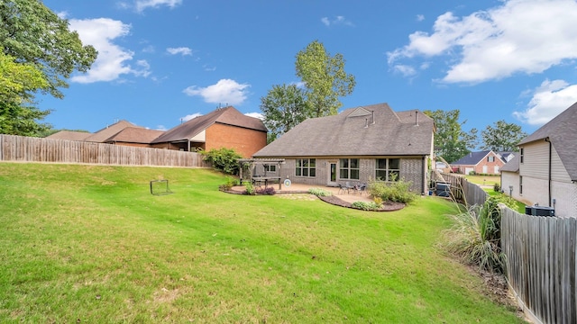 back of house featuring a lawn, a patio area, and central air condition unit