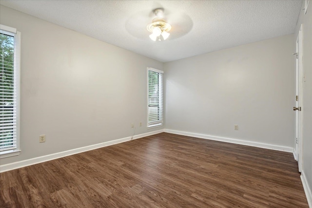 spare room featuring ceiling fan, a textured ceiling, and dark wood-type flooring