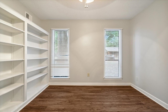 unfurnished room featuring a textured ceiling and dark hardwood / wood-style floors