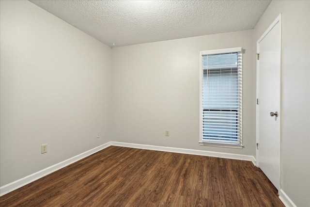 unfurnished room with a textured ceiling and dark hardwood / wood-style floors