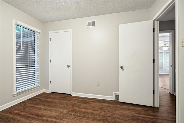 interior space featuring a textured ceiling and dark hardwood / wood-style flooring