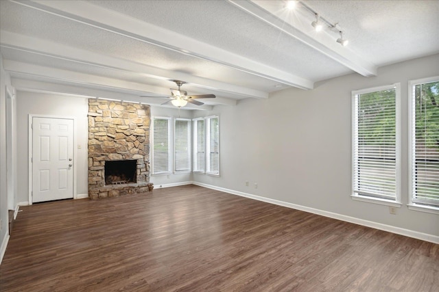 unfurnished living room featuring a textured ceiling, a fireplace, dark wood-type flooring, and ceiling fan