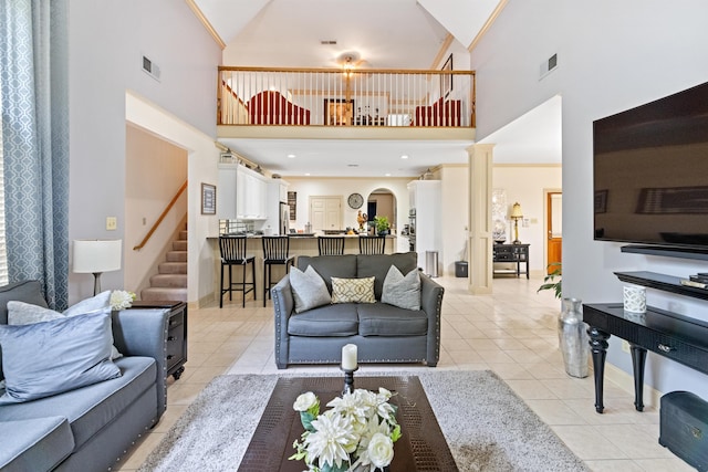 living room featuring high vaulted ceiling, ornamental molding, and light tile patterned floors