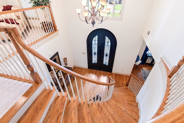 entrance foyer featuring a chandelier, french doors, and hardwood / wood-style flooring