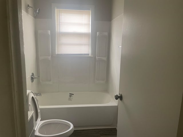 bathroom featuring shower / tub combination, hardwood / wood-style flooring, and toilet