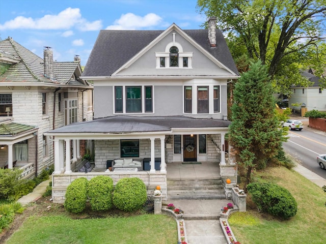 view of front facade featuring covered porch and a front yard