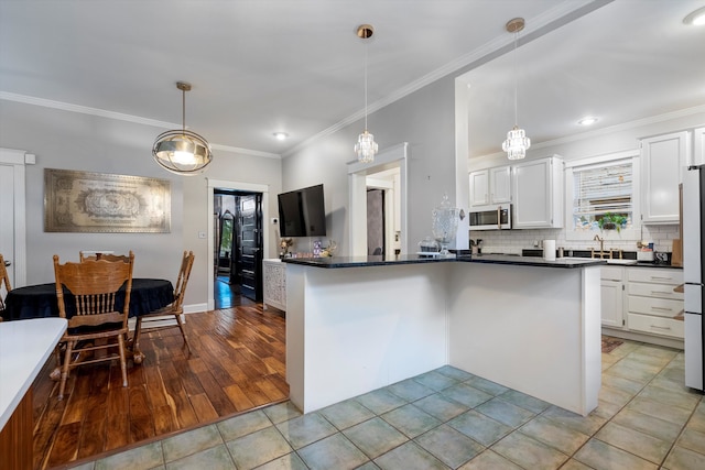 kitchen with light hardwood / wood-style floors, white cabinets, and pendant lighting