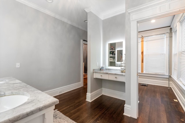 bathroom with vanity, ornamental molding, wood-type flooring, and a healthy amount of sunlight