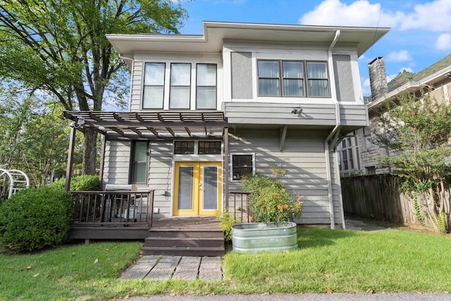 view of front of property featuring a wooden deck, a front lawn, and a pergola