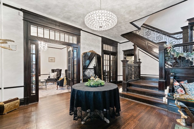 dining area with ornamental molding, a chandelier, and dark wood-type flooring