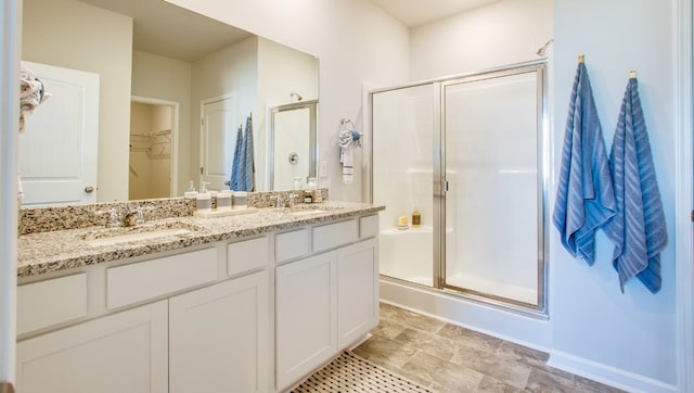 bathroom featuring a shower with door and vanity