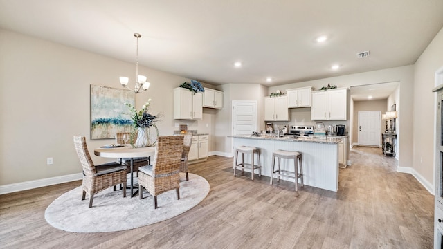 dining room with a notable chandelier and light hardwood / wood-style floors