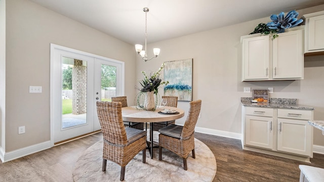 dining area with dark wood-type flooring and a chandelier