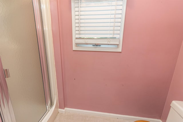 bathroom featuring toilet and an enclosed shower