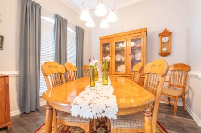 dining room featuring an inviting chandelier, dark hardwood / wood-style floors, and ornamental molding