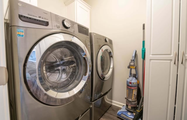 washroom with dark wood-type flooring and washing machine and dryer