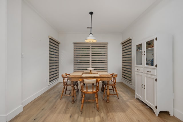 dining space with light hardwood / wood-style floors and ornamental molding