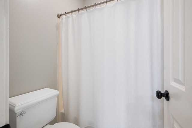 bathroom with shower / bath combination with curtain and toilet