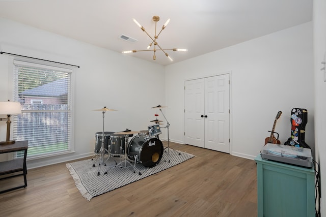 misc room with an inviting chandelier and hardwood / wood-style floors