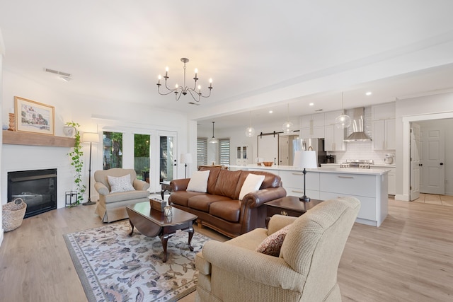 living room featuring an inviting chandelier and light hardwood / wood-style flooring