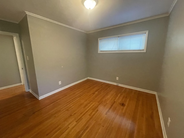 empty room featuring hardwood / wood-style flooring and crown molding