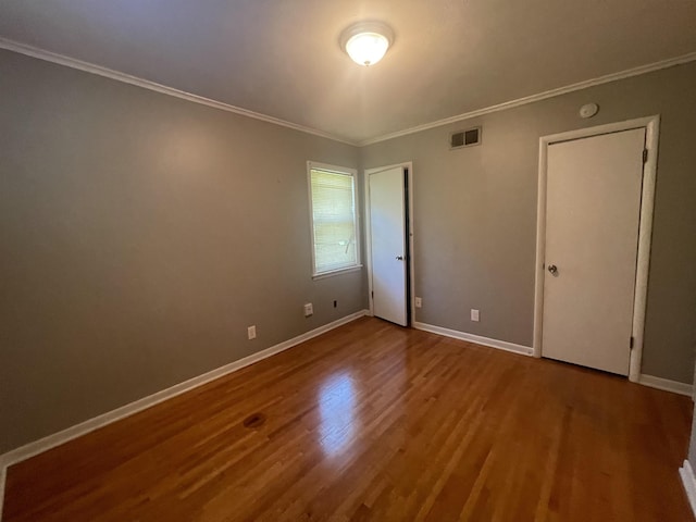 unfurnished bedroom with ornamental molding and hardwood / wood-style floors