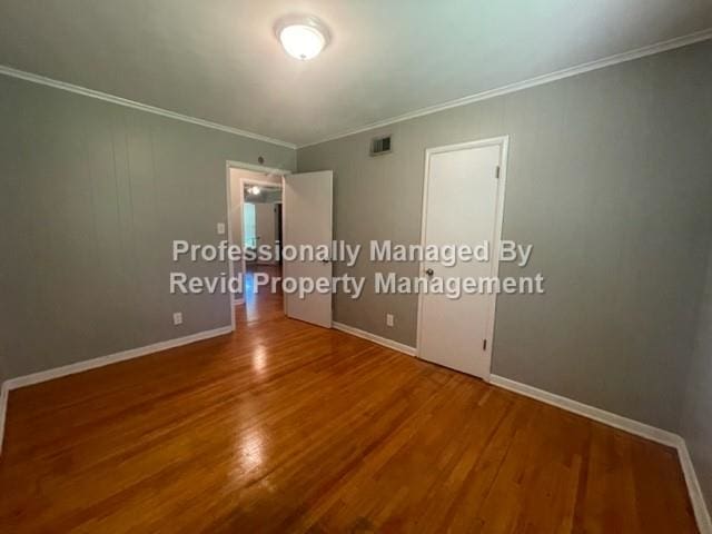 unfurnished room with ornamental molding and hardwood / wood-style flooring