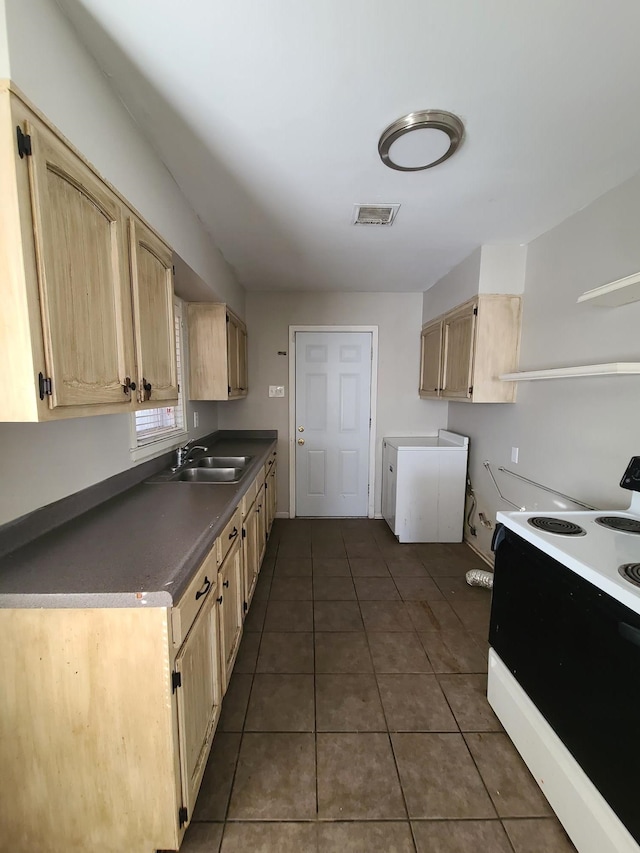 kitchen with electric stove, light brown cabinetry, sink, and dark tile patterned floors