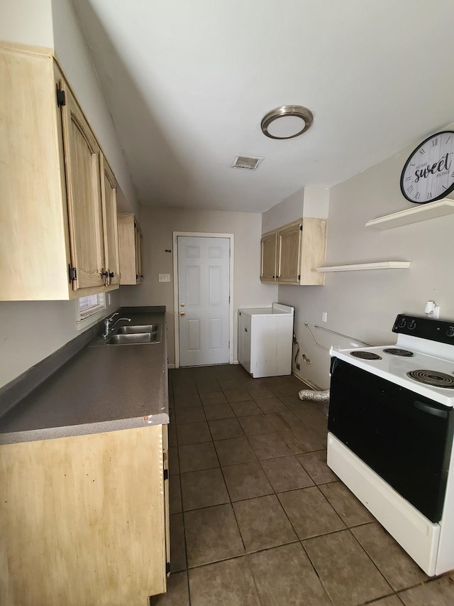 kitchen with dark tile patterned floors, light brown cabinets, white range with electric stovetop, and sink