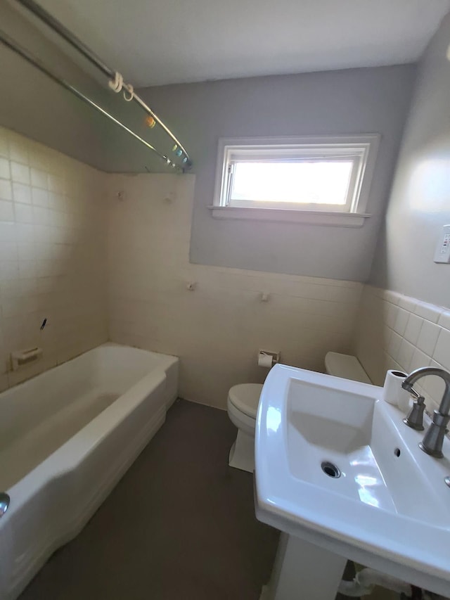 full bathroom with shower / bathing tub combination, sink, tile walls, and toilet