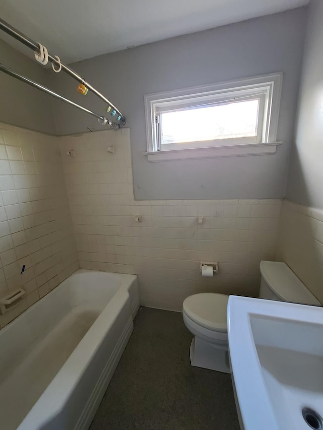 full bathroom featuring sink, tile walls, tiled shower / bath combo, and toilet