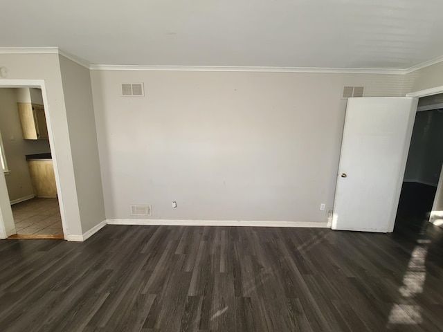 empty room with ornamental molding and dark wood-type flooring