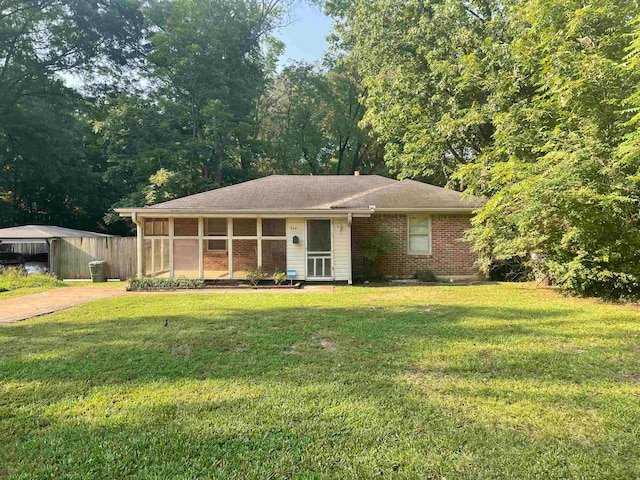 view of front of home featuring a front yard and a sunroom