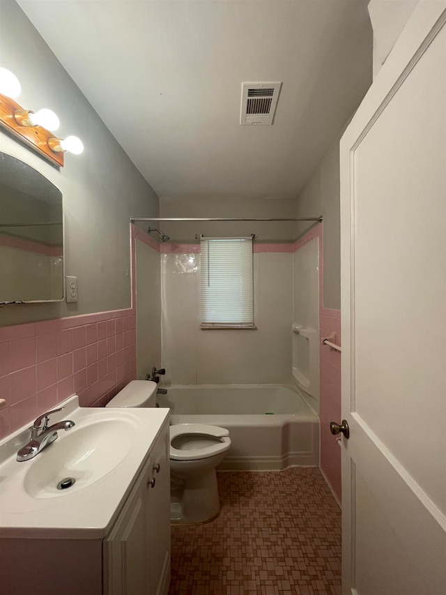 full bathroom featuring  shower combination, vanity, tile walls, and toilet