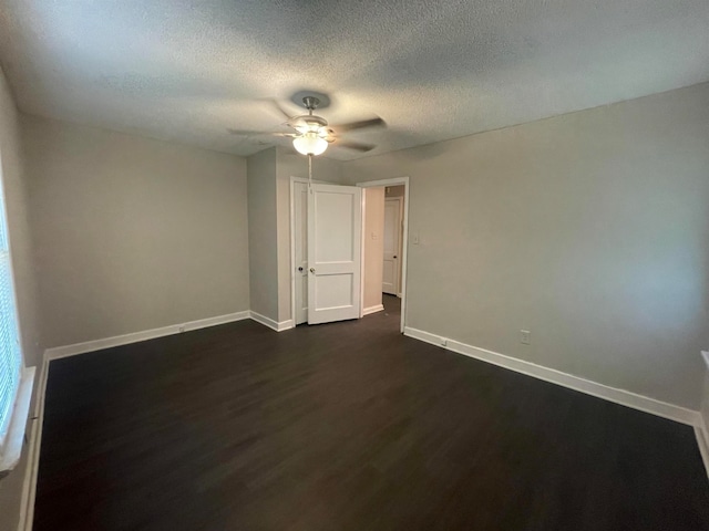 spare room with a textured ceiling, dark hardwood / wood-style flooring, and ceiling fan