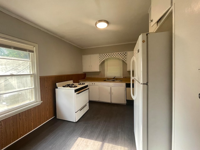 kitchen with white cabinets, wood walls, white appliances, dark hardwood / wood-style floors, and crown molding