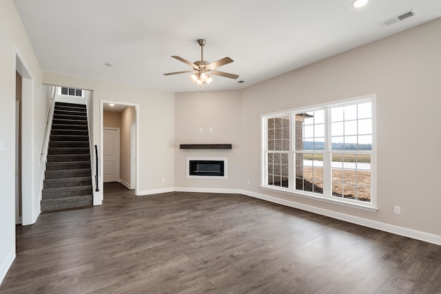 unfurnished living room with dark hardwood / wood-style floors and ceiling fan