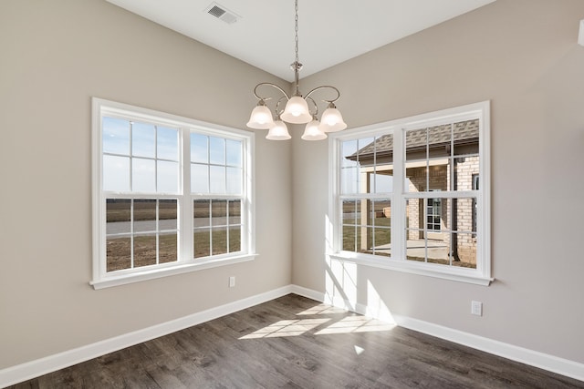 unfurnished dining area with an inviting chandelier and dark wood-type flooring