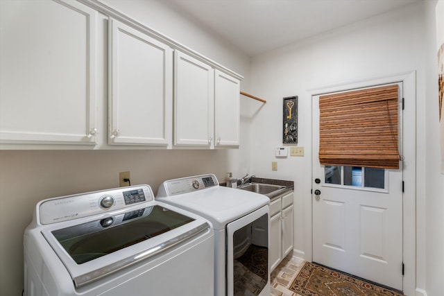 clothes washing area with sink, washer and dryer, and cabinets