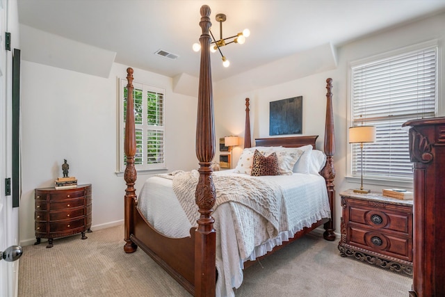 bedroom with a chandelier and light colored carpet