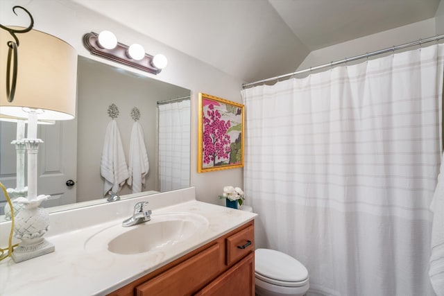 bathroom featuring vaulted ceiling, vanity, toilet, and curtained shower