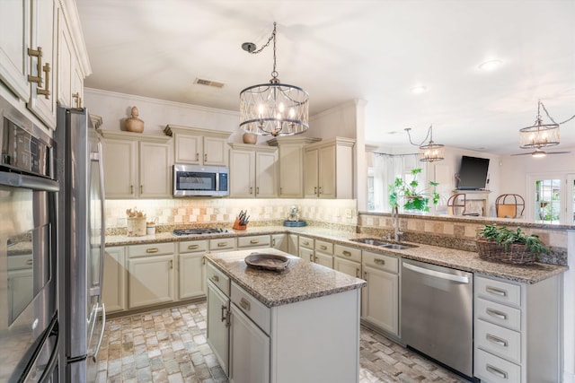 kitchen with pendant lighting, a center island, sink, stainless steel appliances, and crown molding