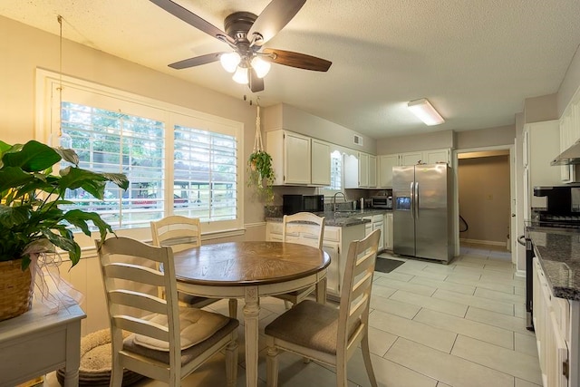 dining room featuring ceiling fan, a textured ceiling, and sink