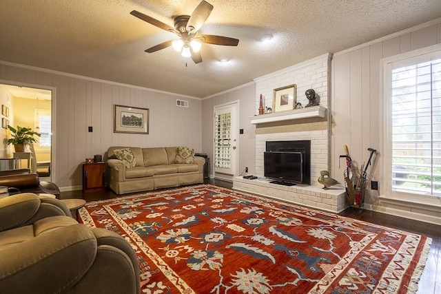 7150 Woodridge Ln, Germantown, TN 38138 - living room with wood finished floors, ceiling fan, ornamental molding, a brick fireplace, and visible vents