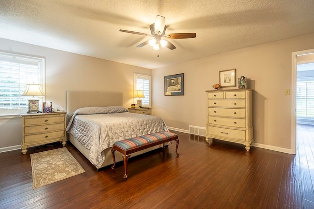 bedroom featuring dark wood-type flooring, multiple windows, and ceiling fan