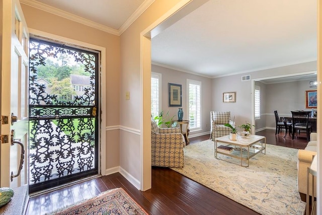 entryway with ornamental molding and dark hardwood / wood-style floors